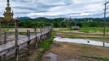 Tepe kabilesinin köyündeki muhteşem güzelliğin havadan görünüşü. Pilav tarlalarından geçen köprü ruhban sınıfıyla cemaati birbirine bağlayan Mae Hong Son 'un en uzun ve en güzel bambu köprülerinden biridir.