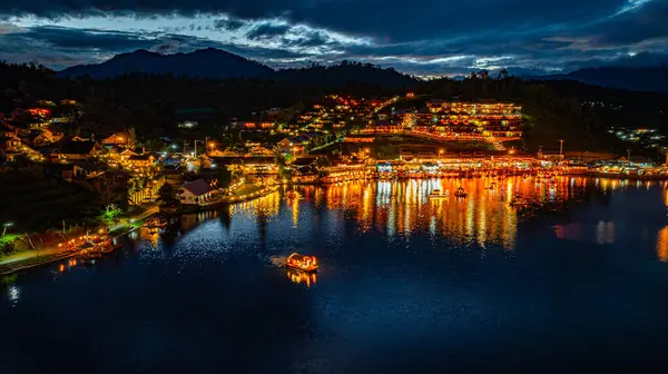 Baan Rak Tayland Köyü, gün batımında Çin tarzı mimaride göl kenarındaki ev ve restoranların renkli ışıklarla yansıması. Mae Hong Son 'da popüler bir turizm merkezi.