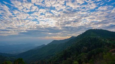 Gün doğumunda dağların tepesinde güzel bulutların hızlanması