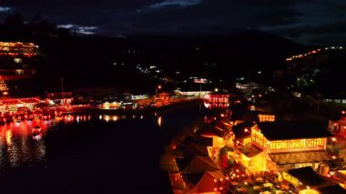 Çin köyü geceleri gölün üzerinde parlayan ışıklarla