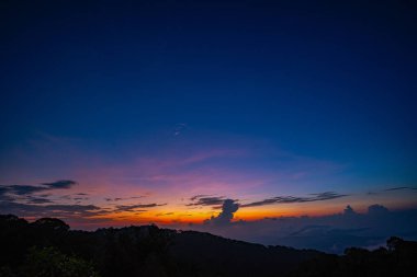 Alacakaranlıkta gökyüzünün alacakaranlıkta önplandaki tepeler üzerindeki manzarası uzaktaki sisli vadilere derinlik ve kontrastlık ekler. Doğanın o muhteşem atmosferik manzarası.. 