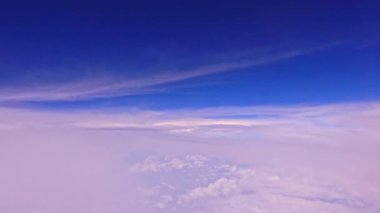 Uçak penceresinden mavi gökyüzünde beyaz bulutların manzarası