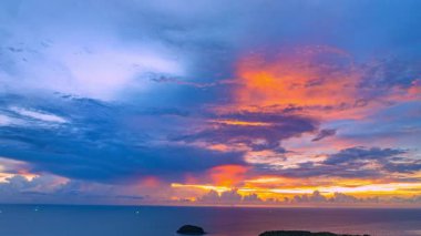Gün batımında okyanusun üzerinde renkli bulutlar olan dramatik gökyüzü manzarası 