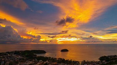Alacakaranlıktaki kıyı kenti üzerindeki renkli bulutların hava manzarası