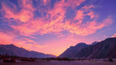 Nubra Vadisi 'ndeki kum tepeciğinin üzerinde gün batımı manzarası