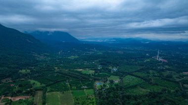 Yoğun bulutlarla kaplanmış gür, gür bir dağ zirvesinin dramatik manzarası, bulutlu bir gökyüzü altında doğanın saf güzelliğini ve gizemini yakalıyor..