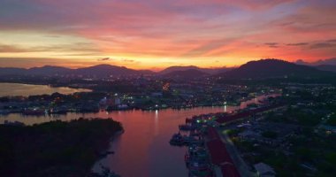 Gün batımında balıkçılık limanında gökyüzündeki renkli bulutların hava görüntüsü 