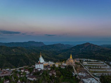 Hava manzarası gün batımında muhteşem Büyük Beyaz Buda heykelleri. Wat Phachonkeaw 'un güzel altın köşkü Tayland' ın çok güzel ve ünlü bir simgesi olan tepede mücevherler ve taşlarla süslenir..