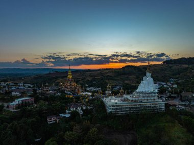 Hava manzarası gün batımında muhteşem Büyük Beyaz Buda heykelleri. Wat Phachonkeaw 'un güzel altın köşkü Tayland' ın çok güzel ve ünlü bir simgesi olan tepede mücevherler ve taşlarla süslenir..