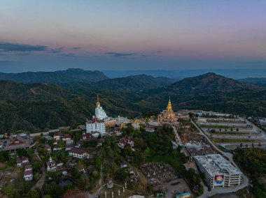 Hava manzarası gün batımında muhteşem Büyük Beyaz Buda heykelleri. Wat Phachonkeaw 'un güzel altın köşkü Tayland' ın çok güzel ve ünlü bir simgesi olan tepede mücevherler ve taşlarla süslenir..
