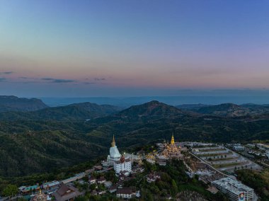 Hava manzarası gün batımında muhteşem Büyük Beyaz Buda heykelleri. Wat Phachonkeaw 'un güzel altın köşkü Tayland' ın çok güzel ve ünlü bir simgesi olan tepede mücevherler ve taşlarla süslenir..