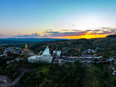 Hava manzarası gün batımında muhteşem Büyük Beyaz Buda heykelleri. Wat Phachonkeaw 'un güzel altın köşkü Tayland' ın çok güzel ve ünlü bir simgesi olan tepede mücevherler ve taşlarla süslenir..