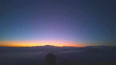 Gün doğumunda dağlarda sislerin üzerinde tatlı gökyüzünün zaman kayması