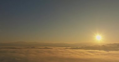 Sabahın erken saatlerinde vadideki sislerin üzerinde yükselen güneşin çarpıcı hava manzarası. 