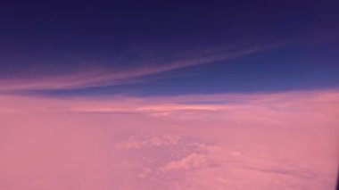 Dünya üzerindeki beyaz bulutların üzerindeki uçak penceresinden bak