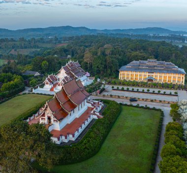 Sis arka planında Baan Khan Tapınağı 'nın havadan görünüşü. Perspektif, güzel bir gökyüzü altında sis ve kırsal alanlarla çevrili karmaşık altın kuleleriyle çarpıcı bir Tayland tapınağını gözler önüne seriyor..