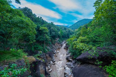 Nehir vadisinin güzel manzarası, kayalıkları öpmek ve uçurumları birbirine bağlayan dar köprüler gibi yüksek kaya oluşumlarıyla dolu yemyeşil ormanlarla çevrilidir. Rive 'de muhteşem bir öpüşme.
