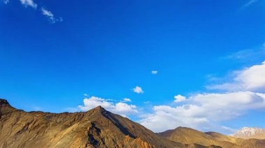 Dağ Vadisi 'ndeki mavi gökyüzünde dramatik beyaz bulutların zaman akışı