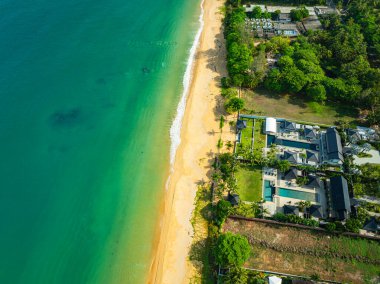 Altın kumlu plajlar, yemyeşil çam ağaçları ve kıyıya çarpan turkuaz okyanus dalgalarının yer aldığı çarpıcı bir hava manzarası. Seyahat ve doğa görselleri için mükemmel.. 