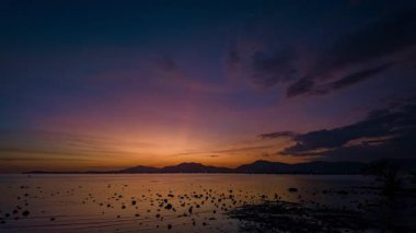 Gün batımında, dağların tepesinde tatlı, renkli gökyüzünün zaman akışı.