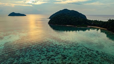 Sakin tropikal ada sularına yansıyan günbatımı