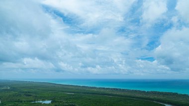 Turkuaz okyanus kıyı şeridinin üzerindeki geniş bulutlu gökyüzü