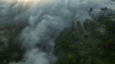 manzara, sisli katmanlar ve ufku boyayan canlı renklerle. Huzurlu atmosfer ve doğal güzellik