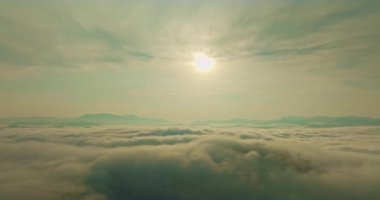 Güneş yoğun bulutların üzerinde parlıyor.