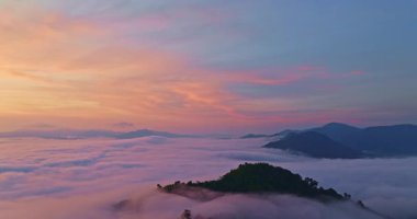 Sisli dağ manzarasının üzerinde renkli gündoğumu gökyüzü