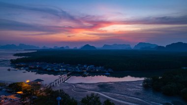 Alacakaranlıktaki Bang Phat balıkçı köyündeki gökyüzü manzarası. Mangrov ormanlarıyla çevrili küçük, ıssız bir adada yaşayan bir balıkçı köyündeki alacakaranlık gökyüzünün yansıması..