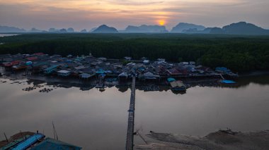 Küçük bir köprünün havadan görünüşü, mangrov ormanlarıyla çevrili küçük bir adada yaşayan bir balıkçı köyüne bağlanır. Önünde denize açılan bir kanal var, çeşitli deniz yaşamı açısından zengin..