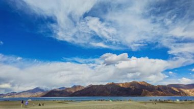 Uzak dağ gölünün üzerinde hareketli dramatik bulutlar
