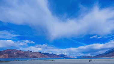 Uzak dağ sırasının üzerinde dramatik bulutlar oluşuyor.
