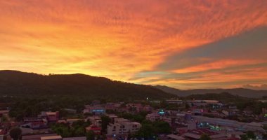 Uzak tepelerin üzerinde canlı turuncu günbatımı gökyüzü