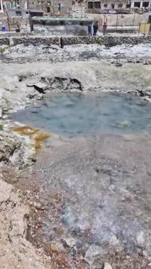 Kayalık araziyle çevrili buharlı jeotermal kaplıca.