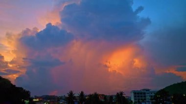 Şehir binalarının üzerinde parlayan dramatik günbatımı bulutları