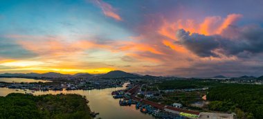 Durgun denizi yansıtan canlı sarı, pembe ve mor gün batımının nefes kesici görüntüsü. Bu sakin sahne Phuket balıkçılık limanında doğanın renklerinin güzelliğini yakalar. renkli bulut manzarası arkaplanı