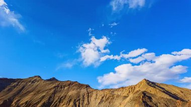 Bulutlu engebeli dağ sırtının üzerindeki mavi gökyüzü
