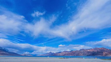 Sakin dağ gölünün üzerinde dramatik bulutlar sürükleniyor.