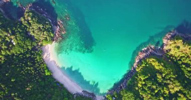 Turkuaz su, beyaz kumlu sahil şeridiyle buluşuyor.