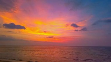 Sakin okyanus suyuna yansıyan canlı günbatımı gökyüzü