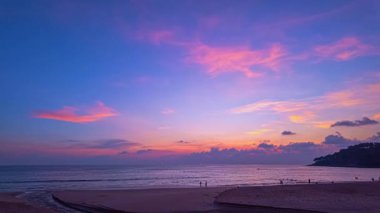 Sakin okyanus dalgalarının üzerinde renkli günbatımı gökyüzü
