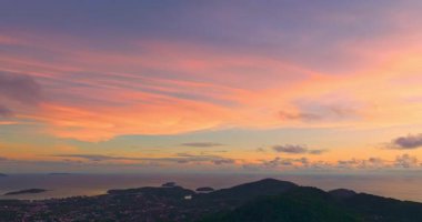 Uzak sahil tepelerinin üzerinde renkli günbatımı gökyüzü