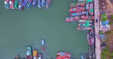 Yeşil suda birlikte yüzen renkli tekneler.