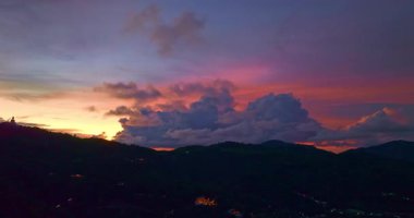 Karanlık yuvarlanan tepelerin üzerinde renkli günbatımı gökyüzü