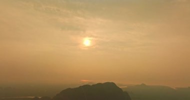 Yumuşak güneş ışığı uzak dağ siluetinin üzerinde parlıyor