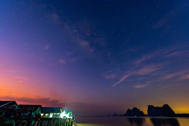 Durgun suyun üzerine yansıyan renkli günbatımı gökyüzü