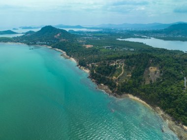 Hava görüntüsü turkuaz kıyı şeridi buluşmasını gösteriyor yemyeşil tepeler