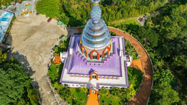 Etrafı yemyeşil ağaçlarla çevrili renkli tapınak binası