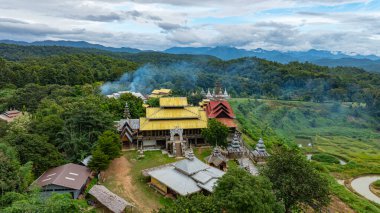 Geleneksel köy binalarını çevreleyen yemyeşil tepeler